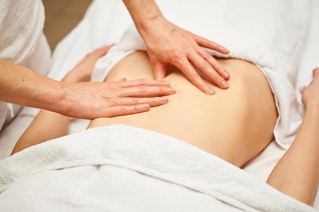 hands on the back of a patient doing massage therapy