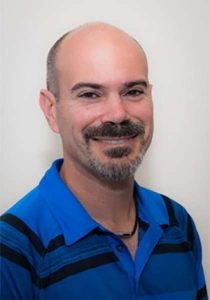 Dr-Charles-Kathopoulis in a blue collared shirt